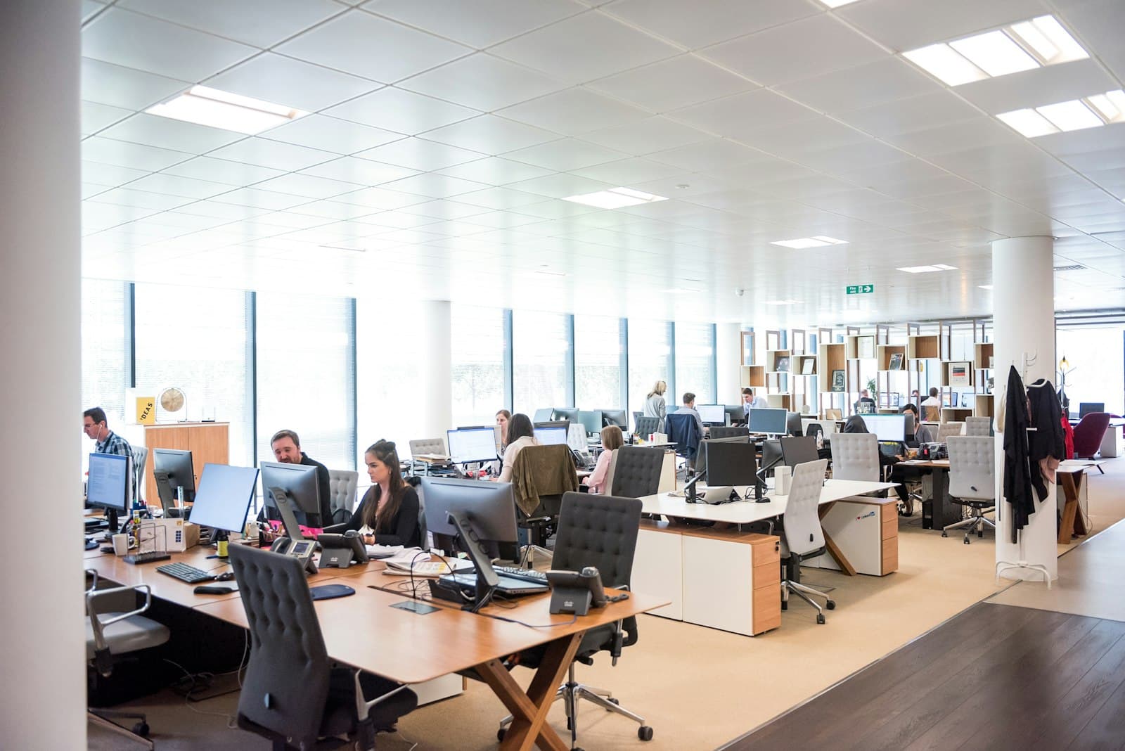 Staff working at desks with computers and desk phones in a bright open-plan office